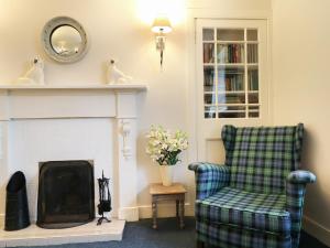 a living room with a chair and a fireplace at Kerrisdale in Dornoch