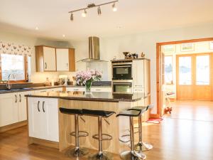 a kitchen with a island with bar stools at Corriemhor Beag in Cromdale