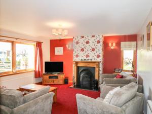 a living room with two couches and a fireplace at Corriemhor Beag in Cromdale