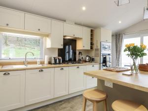 a kitchen with white cabinets and a counter at Woodstock Lodge in Skelmorlie