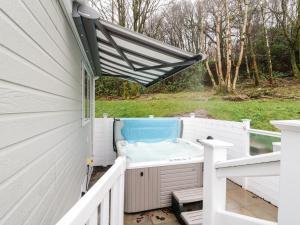 a hot tub on the side of a house at Woodstock Lodge in Skelmorlie