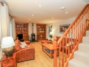 a living room with a staircase and a couch at Fig Tree Cottage in Cadeleigh