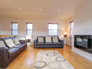 uma sala de estar com dois sofás de couro e uma lareira em Wrenville em Keswick