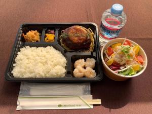 una caja de almuerzo con arroz y un tazón de comida en Ohta Grand Hotel, en Ōta