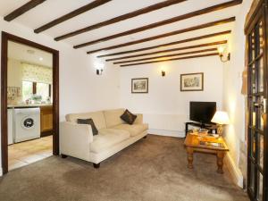 a living room with a couch and a table at Rosegarth Cottage in Morland
