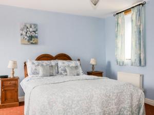 MorlandにあるRosegarth Cottageの青い壁のベッドルーム1室(大型ベッド1台付)