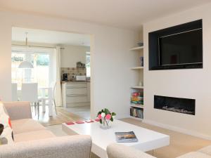 a living room with a couch and a tv on a wall at Chy Kerris, Carbis Bay in Carbis Bay