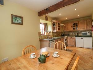 a kitchen with a wooden table and chairs and a kitchen with a table at The Stables in Sturminster Newton