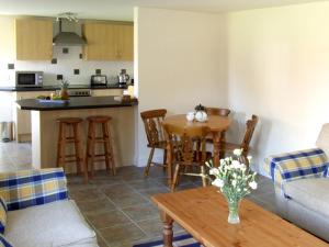 un soggiorno con divano e tavolo e una cucina di The Dairy a Stratford-upon-Avon