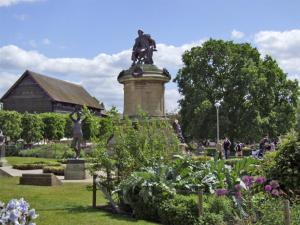 Una statua di un uomo su un cavallo su un pilastro in un giardino di The Dairy a Stratford-upon-Avon