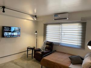 a living room with a couch and a chair and a television at CRIB 253 Subic Bay in Olongapo