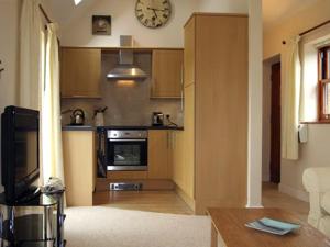 a kitchen with a clock on the wall and a stove at Lodge Cottage in York