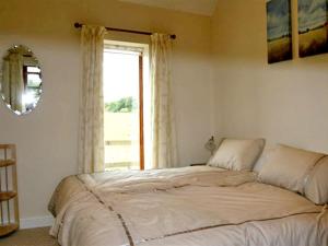 a bedroom with a large bed in front of a window at Lodge Cottage in York