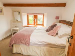 um quarto com uma grande cama branca e uma janela em Swallow Barn em Keighley