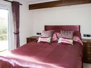 a bedroom with a large bed with purple sheets and a window at Westview in Weston-super-Mare