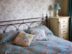 1 dormitorio con 1 cama con almohadas y vestidor en The Old Corn Store, en Keighley