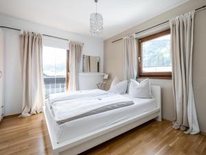 ein weißes Bett in einem Zimmer mit Fenster in der Unterkunft Fleckalm in Kirchberg in Tirol
