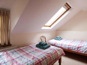 a attic bedroom with two beds and a skylight at Kingsley Cottage in Hickling