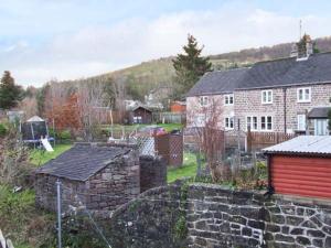 einen Hof mit einer Steinmauer und einem Haus in der Unterkunft Bobbin Cottage in Matlock