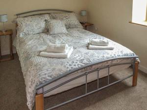 ein Schlafzimmer mit einem großen Bett mit Handtüchern darauf in der Unterkunft The Old Byre in Ludlow