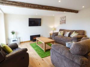 a living room with two couches and a table at The Hayloft in Oswestry