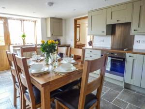 a kitchen with a wooden table with chairs and a dining room at The Hayloft in Oswestry