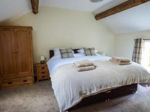 a bedroom with a bed with two pillows on it at The Hayloft in Oswestry