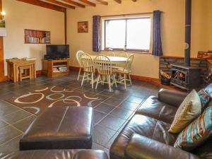 ein Wohnzimmer mit einem Sofa und einem Tisch in der Unterkunft Y Bwthyn in Ystrad Meurig