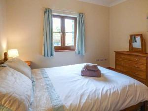 Schlafzimmer mit einem großen weißen Bett und einem Fenster in der Unterkunft Y Bwthyn in Ystrad Meurig