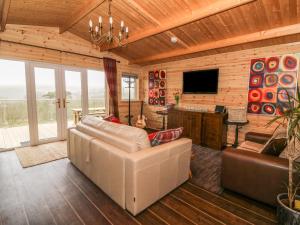 a living room with a couch and a television at The Cabin in Garnant