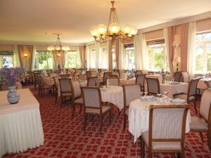 a restaurant with tables and chairs and a chandelier at Hotel Moderno in Premeno