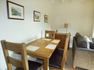 a dining room with a table and a couch at Mill Cottage in Wolsingham
