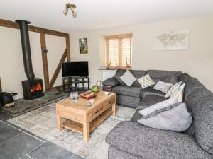 a living room with a couch and a fireplace at Tynddol Barn in Llanbadarn-fynydd