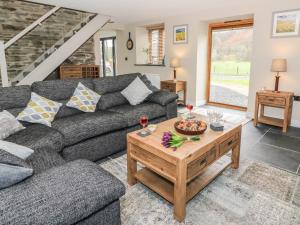a living room with a couch and a coffee table at Tynddol Barn in Llanbadarn-fynydd