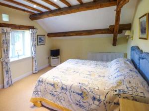 a bedroom with a blue and white bed in a room at Pheasant Cottage in Grange Over Sands