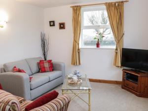 a living room with a couch and a television at Rose Villa in Llanymynech