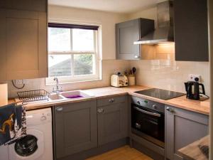 a kitchen with a sink and a washing machine at Beacon Cottage in Ilkley