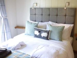 a bedroom with a large bed with pillows at Squirrel Lodge in Skipton