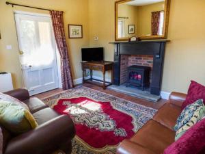 a living room with a couch and a fireplace at The Gate House in Oakamoor