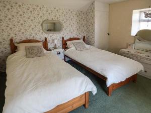 a bedroom with two beds and a window at Church View in Hartington