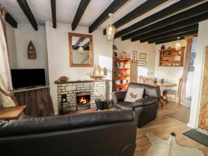 a living room with a couch and a fireplace at Merlin in Pwllheli