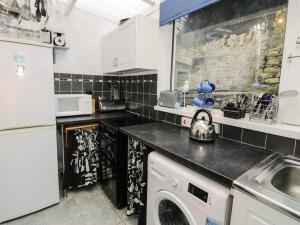 a kitchen with a washing machine and a sink at Merlin in Pwllheli