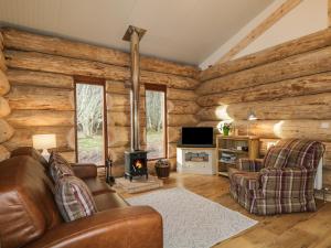 a living room with a couch and a stove at Moorhen Lodge in Inverness