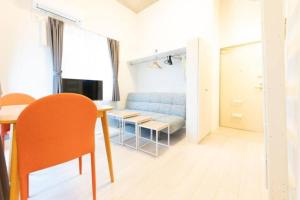 ラフィット両国 في طوكيو: غرفة معيشة مع أريكة زرقاء وطاولة