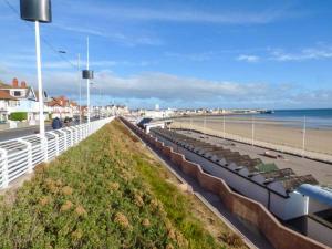 a beach with a row of chairs and the ocean at Flat 3 in Bridlington
