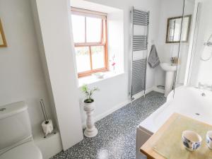 un bagno con vasca, WC e lavandino di Barn Cottage a West Burton Altre 14 foto