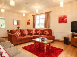 sala de estar con sofá y mesa en The Cabin en Ilfracombe