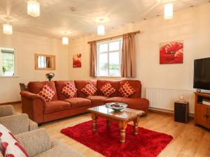 ein Wohnzimmer mit Sofa und Tisch in der Unterkunft The Cabin in Ilfracombe