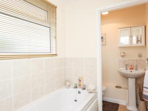 ein Badezimmer mit Badewanne und Waschbecken in der Unterkunft The Cabin in Ilfracombe + 16 Fotos