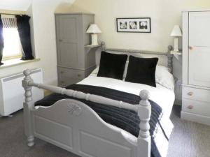LastinghamにあるBecksideの白いベッド(黒い枕付)が備わるベッドルームです。
